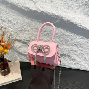Pink mini handbag with rhinestone bow decoration and silver chain strap