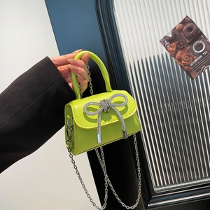 Neon green mini handbag with rhinestone bow decoration and silver chain strap