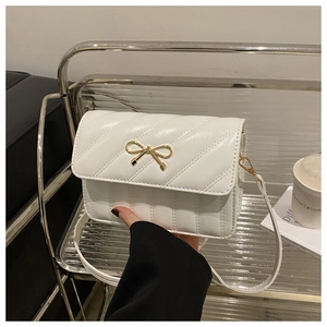 Détail du sac bandoulière matelassé blanc avec fermoir nœud doré et texture en cuir PU chic