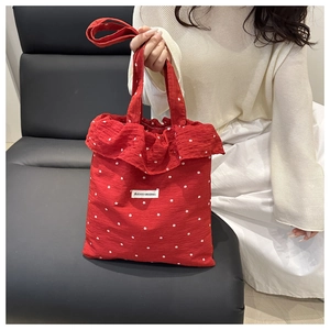 Detail view of red floral tote bag with ruffles and AGOGO ORIGINAL brand label