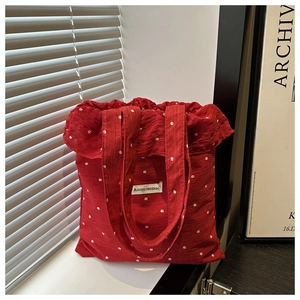 Dettaglio della borsa rossa in chiffon a fiori con coulisse ed etichetta AGOGO ORIGINAL