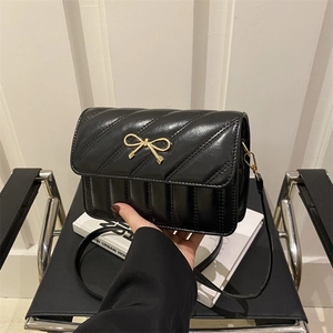 Chic black quilted square shoulder bag featuring a gold bow buckle and PU leather finish