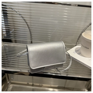 Detail of silver matte mini crossbody bag for girls on a stylish wavy acrylic shelf