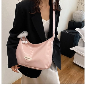 Roze zachte PU-lederen hobo tas met wit modelabel en een pluche wolkenhanger