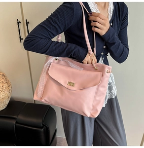 Detail of pink faux leather tote with golden twist lock and white lace trim decoration