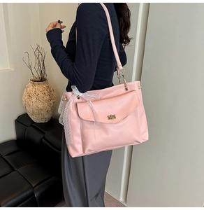 Pink oversized tote bag with decorative lace ribbon and metal buckle detail