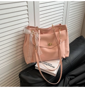 Detail of pink faux leather tote with light gold turn-lock and white lace bow decoration