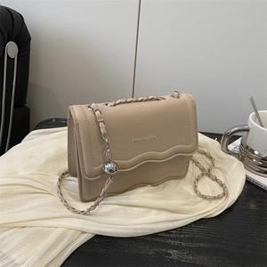 Elegant beige crossbody bag with wavy edge design and gold metal ball chain strap