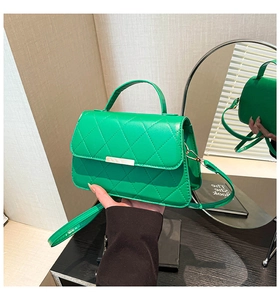 Detail of lime green quilted handbag with gold metal clasp and glossy leather finish