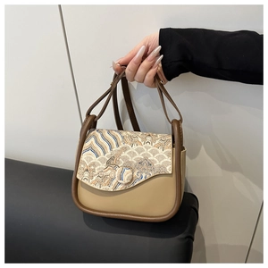 Bordado detallado de patrones de olas tradicionales en un bolso bandolera beige retro