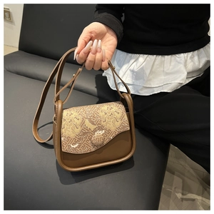 Detalle de bolso bandolera vintage con ribete de cuero marrón y tela con patrón de nubes
