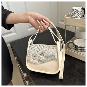 Detalle de bolso cuadrado pequeño vintage crema con bordado tradicional de patrones de olas