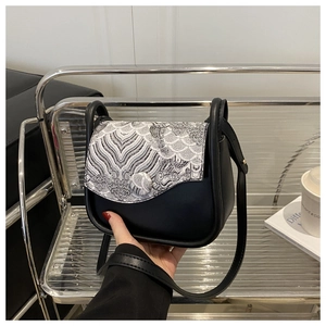Detalle de bolso cuadrado de estilo chino con bordado de nubes y acabado en cuero