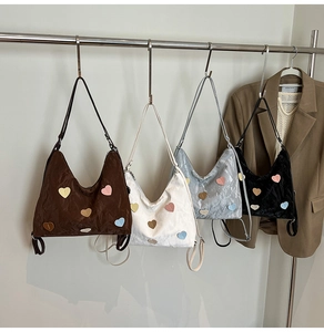 Detail of multi-color heart patches on textured nylon hobo bags in four colors