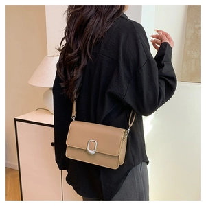 Lifestyle shot showing a khaki minimalist square crossbody bag with a silver metal buckle