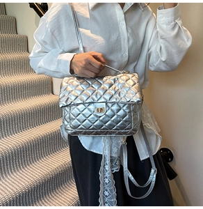 Detail of silver quilted tote bag with metallic leather finish and light gold swivel lock