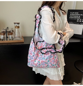 Detail of floral canvas bag featuring black ruffle shoulder strap and sweet spring design