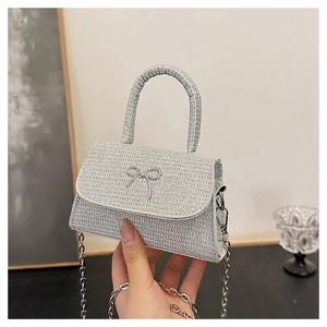 Close-up of silver glitter handbag featuring a minimalist bow and elegant chain strap