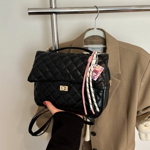 Quilted black leather tote bag with gold hardware and woven strap for summer fashion