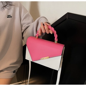 Detailed shot of pink and white color-block leather bag with woven handle and gold lock
