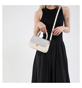 Detail view of stylish crossbody bag with silver glitter flap and gold rotating lock