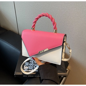 Detail of pink and white crossbody bag with braided handle and gold metal hardware