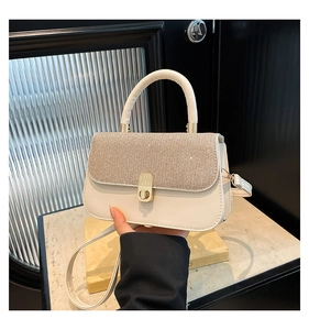 Detail of cream leather bag featuring sparkling rhinestones and metal twist lock