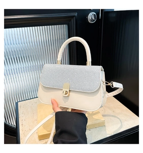 Detailed view of women's vintage square bag featuring silver glitter flap and gold clasp