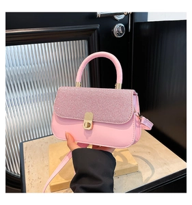 Detailed shot of pink crossbody bag with glitter flap and golden metallic clasp