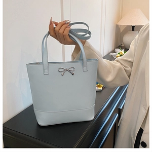 Détail du cabas en cuir bleu clair avec nœud métallique et bandoulière réglable