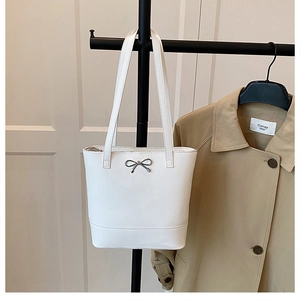 Détail du sac cabas en cuir ciré blanc avec nœud en métal argenté et longues bandoulières