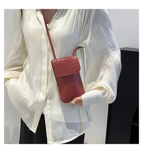 Stijlvolle geweven lederen telefoontas in steenrood gedragen door model met wit shirt