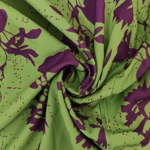 Detailed close-up of vibrant purple floral print on soft green gathered dress fabric