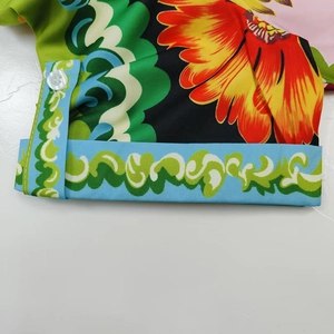 Detail of floral and baroque print shirt with white button and precise stitching