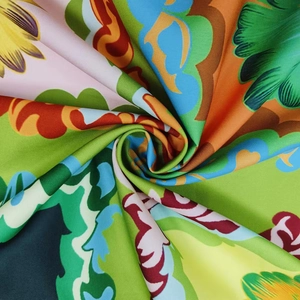 Detail of vibrant tropical floral pattern fabric with smooth satin finish and vivid colors