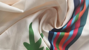 Macro detail of high-quality floral print fabric with colorful stripes and fluid drape