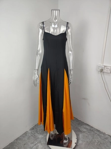 Detail view of contrast stitching and orange pleated panels on a black slip dress