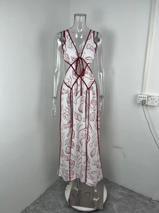 Detail eines weißen Cut-out-Kleides mit roter Schnürung und Meeresprint-Motiven