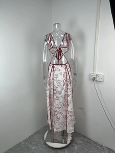 Detail der gekreuzten Rückenschnürung und des roten Blumendrucks auf weißem Maxikleid