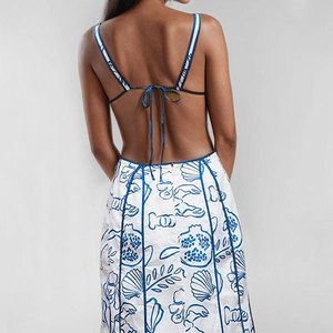 Detail eines sexy rückenfreien Kleides mit blauen Blumendrucken und filigraner Schnürung