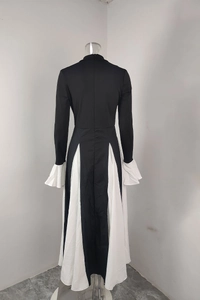Detail of elegant black dress with white contrast triangular hem and flared ruffle cuffs