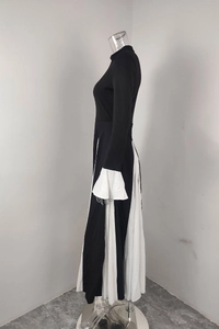 Detail view of the black and white pleated dress with elegant flared contrast cuffs