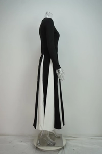Detailed side view of long-sleeved dress with black and white color block pleated skirt