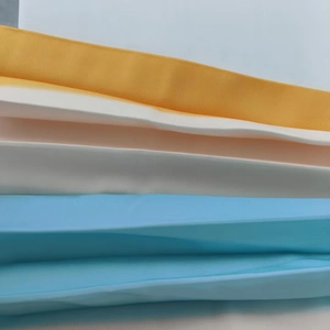 Gros plan d'échantillons de tissu satiné soyeux en tons jaune, blanc et bleu pastel