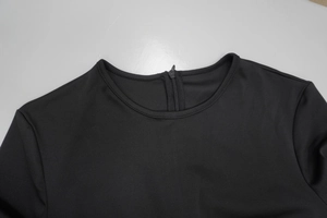Detailed view of the round neckline and back invisible zipper on this black dress