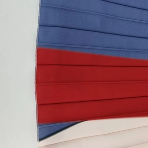 Détail du tissu plissé coloré avec coutures contrastées bleues, rouges et blanches