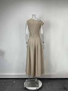 Détail d'une robe longue élégante kaki avec design asymétrique et jupe plissée large