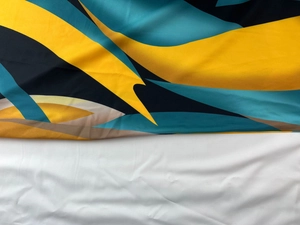 Detail of vibrant geometric print fabric with yellow and teal abstract color blocks