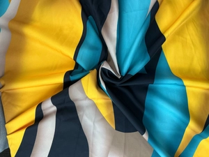 Macro shot of elegant floral print fabric with silky texture and vibrant color blocks