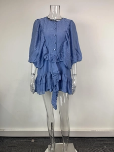 Detail of blue ruffle dress featuring bubble sleeves and textured fabric pleats